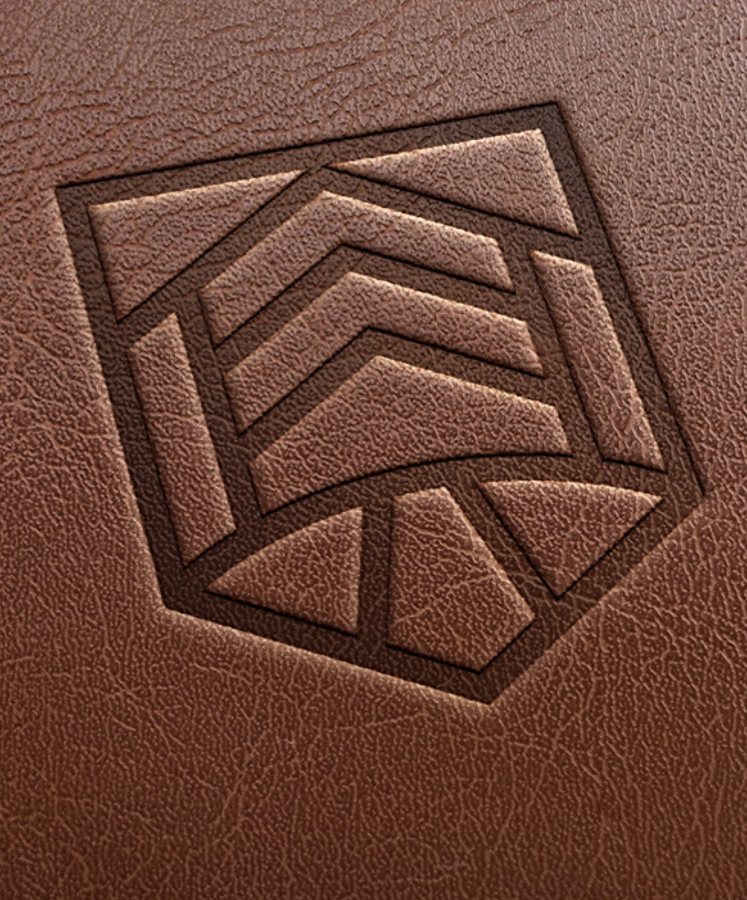 Geometric logo embossed on brown textured leather, featuring a series of angular lines forming a hexagonal pattern.